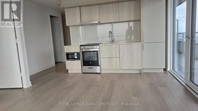 Mississauga (City Centre) condo for rent - A kitchen with white appliances and wooden cabinets.