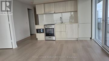 Mississauga (City Centre) condo for rent - A kitchen with white appliances and wooden cabinets.