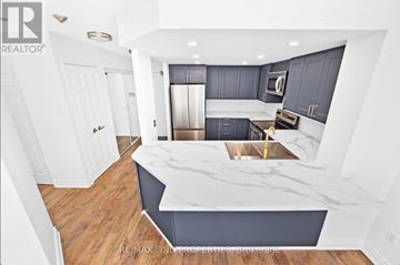 Mississauga (City Centre) condo for rent - A modern kitchen with a marble countertop and stainless steel appliances.