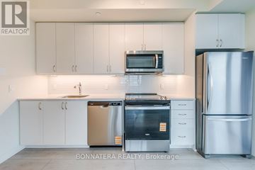 Toronto (Mimico) condo for rent - A modern kitchen with white cabinets and stainless steel appliances.