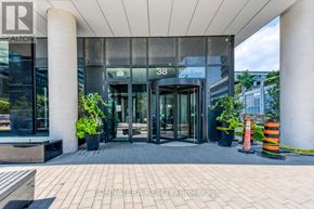 Toronto (Mimico) condo for rent - The entrance to a building with a glass door and a sign that reads "38 ARNIE GRAHAM".