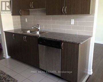 Toronto (Dovercourt-Wallace Emerson-Junction) condo for rent - A kitchen with brown cabinets and a black dishwasher.