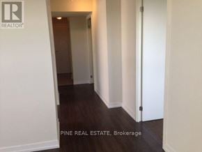 Toronto (Dovercourt-Wallace Emerson-Junction) condo for rent - A hallway with a door on the right and a brokerage sign on the wall.