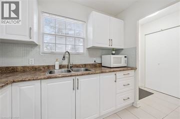 Waterloo townhouse for rent - A kitchen with white cabinets and a brown countertop.