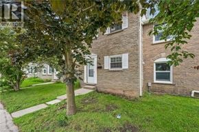 Waterloo townhouse for rent - A tree in front of a brick house with a white door.