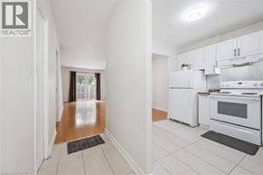 Waterloo townhouse for rent - A kitchen with white appliances and a white tile floor.