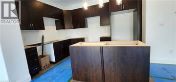 Picton townhouse for rent - A kitchen with dark wood cabinets and a white counter top.