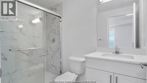 Windsor condo for rent - A white bathroom with a marble shower and toilet.