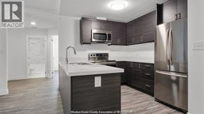 Windsor condo for rent - A modern kitchen with dark wood cabinets and stainless steel appliances.