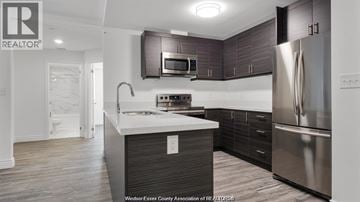 Windsor condo for rent - A modern kitchen with dark wood cabinets and stainless steel appliances.