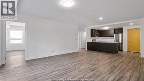 Windsor condo for rent - A spacious living room with a kitchenette in the background.