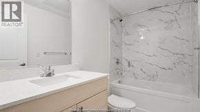 Windsor condo for rent - A bathroom with a marble shower and a white sink.