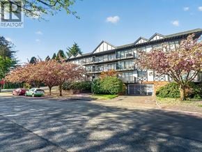 North Vancouver apartment for rent - A green car is parked in front of a building with a sign that says REALTOR.