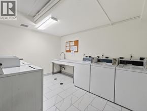 North Vancouver apartment for rent - A clean, white-walled room with a row of white appliances and a white cabinet.