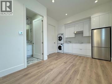 Richmond apartment for rent - A modern kitchen with a refrigerator, oven, and washing machine.