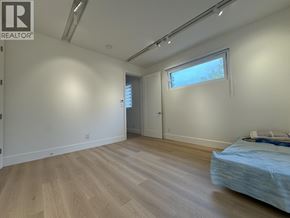 Richmond apartment for rent - A bedroom with a bed, wooden floors, and a window.