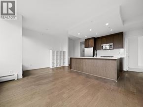 Burnaby apartment for rent - A spacious, empty room with wooden floors and white walls.