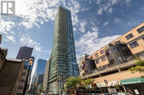 Toronto (Church-Yonge Corridor) condo for rent - A tall building stands in the middle of a city street.