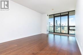 Toronto (Church-Yonge Corridor) condo for rent - A spacious room with a view of the city skyline through large windows.