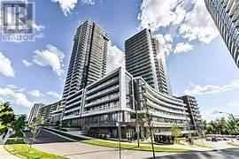 Toronto (Henry Farm) condo for rent - A modern building complex with three tall buildings and a parking lot in front.