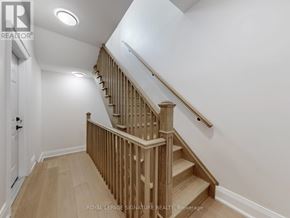 Toronto (Little Portugal) apartment for rent - A wooden staircase with a white wall on the side.