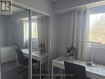 Toronto (Malvern) townhouse for rent - A room with a desk, chair, and mirror.