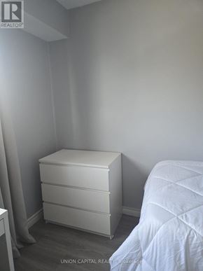 Toronto (Malvern) townhouse for rent - A white bed with a white dresser in a small room.
