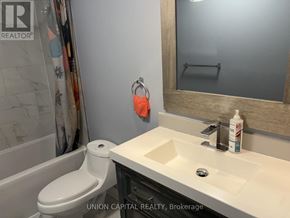 Toronto (Malvern) townhouse for rent - A bathroom with a toilet, sink, and mirror.