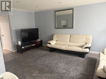 Toronto (Malvern) townhouse for rent - A living room with a white couch and a flat screen TV.