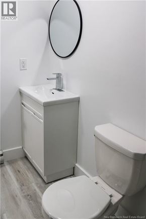 Moncton apartment for rent - A white toilet sits next to a sink in a small bathroom.