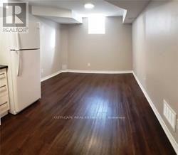 Oakville (Wt West Oak Trails) apartment for rent - A room with wooden flooring and a white refrigerator.