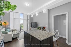 Toronto (Edenbridge-Humber Valley) condo for rent - A modern kitchen with a granite countertop and white chairs.