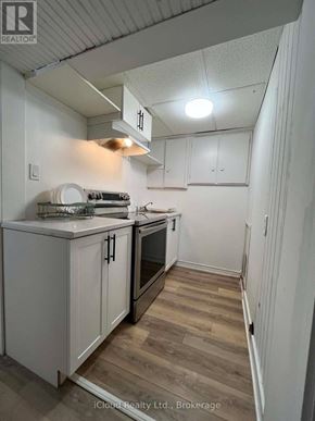 St. Catharines (Burleigh Hill) apartment for rent - A kitchen with white cabinets and a wooden floor.