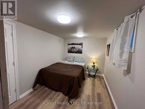 St. Catharines (Burleigh Hill) apartment for rent - A bedroom with a bed, a nightstand, and a lamp.