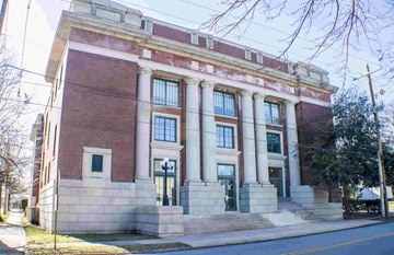 Little Rock apartment for rent - A red brick building with white columns and a green door.