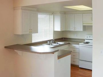 Puyallup apartment for rent - A kitchen with white cabinets and a stainless steel sink.