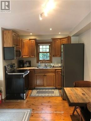 Niagara-On-The-Lake (Town) apartment for rent - A kitchen with wooden cabinets and a black refrigerator.
