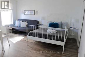 Toronto (Church-Yonge Corridor) condo for rent - A white bed with a white headboard and a white nightstand with a lamp on it.