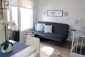 Toronto (Church-Yonge Corridor) condo for rent - A living room with a grey couch, a white coffee table, and a blue rug.