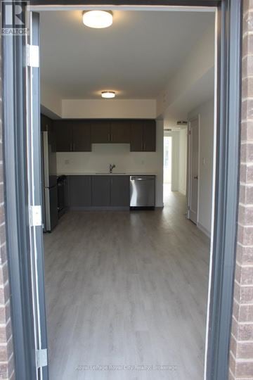 Guelph (Clairfields/Hanlon Business Park) townhouse for rent - A kitchen with a refrigerator and a sink is visible through an open door.