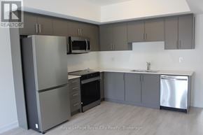 Guelph (Clairfields/Hanlon Business Park) townhouse for rent - A kitchen with a refrigerator, microwave, oven, and sink.