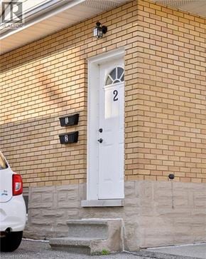 Kitchener apartment for rent - A white door with a number 2 on it is on a brick building.