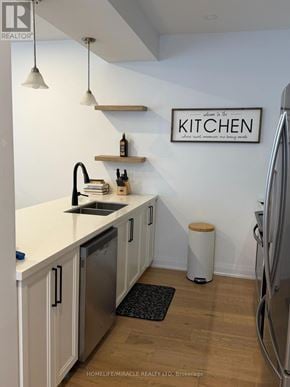 Barrie (East Bayfield) townhouse for rent - A kitchen with white cabinets and a wooden shelf above the sink.
