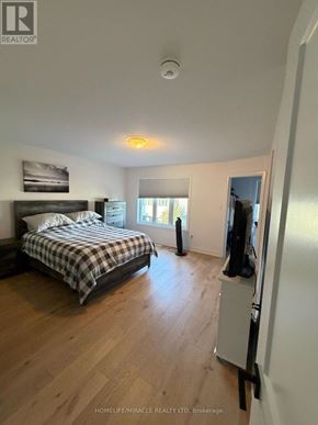 Barrie (East Bayfield) townhouse for rent - A bedroom with a bed, a window, and a fridge.