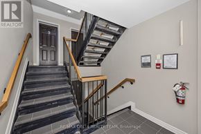 Ottawa condo for rent - A staircase with a wooden handrail and a black metal balustrade.