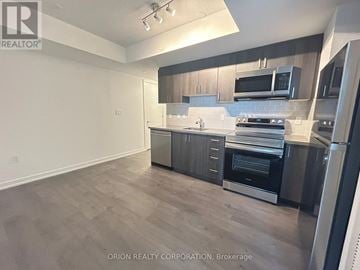 Toronto (Yorkdale-Glen Park) condo for rent - A kitchen with a refrigerator, oven, and microwave.