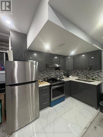 Brampton (Northwest Brampton) apartment for rent - A modern kitchen with a stainless steel refrigerator and marble countertops.