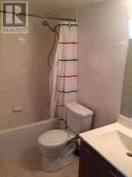 Toronto (South Parkdale) condo for rent - A white toilet sits next to a sink in a small bathroom.