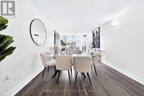 Toronto (Banbury-Don Mills) condo for rent - A dining room with a round mirror on the wall and a wooden floor.