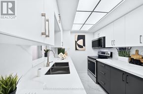 Toronto (Banbury-Don Mills) condo for rent - A modern kitchen with white cabinets and a black countertop.